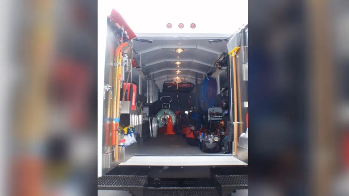 Open plumbing service van stocked with repair equipment for Plumber van on a snowy Parker street