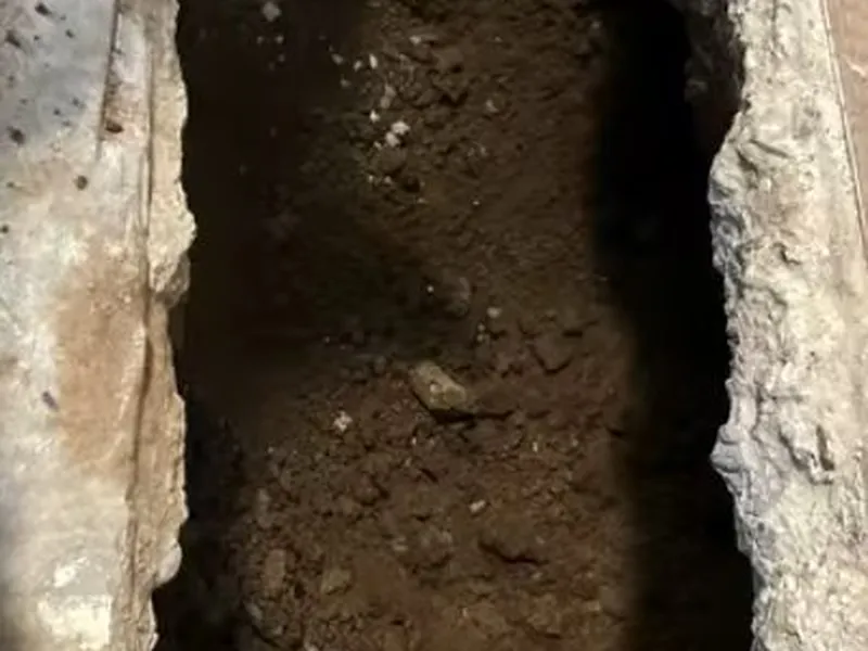 Opened concrete slab and under-floor pipe repair area for Disposal flange leak repair