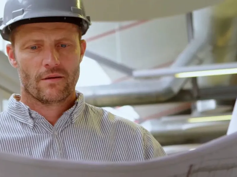 Plumber reviewing plans for a pipe layout for Upfront pricing with a Parker homeowner